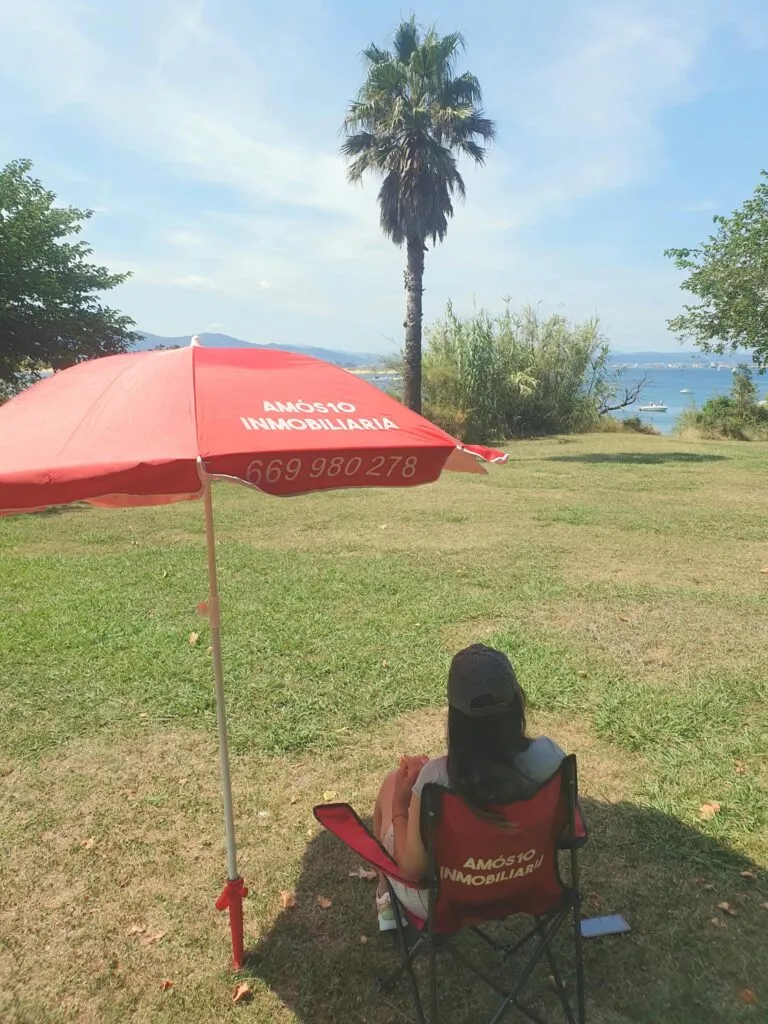 Amós 10 Inmobiliaria con su sombrilla de playa junto a la bahía de Santander